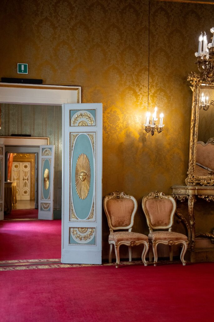 Porta decorata e poltrone d’epoca nei salotti di Palazzo Borghese